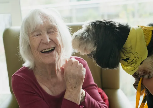 mujer anciana junto a perro de terapia