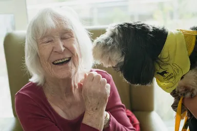 mujer anciana junto a perro de terapia