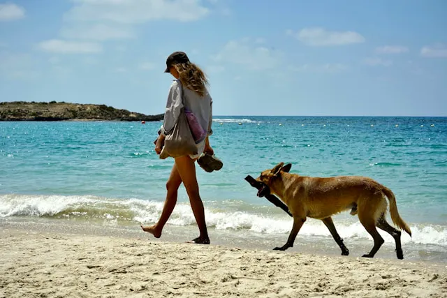 perro con mujer en la playa